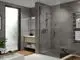 Badezimmer mit ebenerdiger Dusche, Chrom-Duscharmatur von Ideal Standard, Holzregal für Handtücher, moderner Waschtisch und große Fenster für Tageslicht.